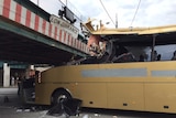 The wreckage of the bus, wedged under the bridge.