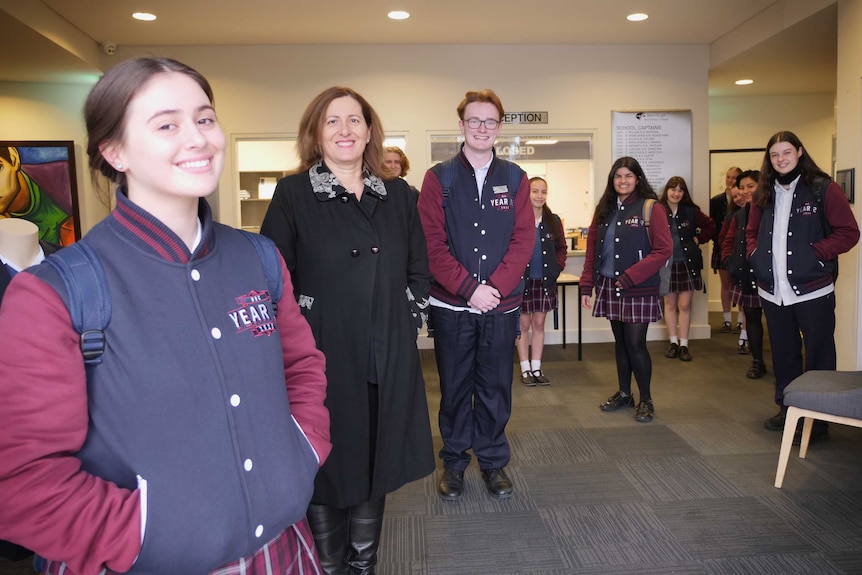 Students stand with the principal in the reception area