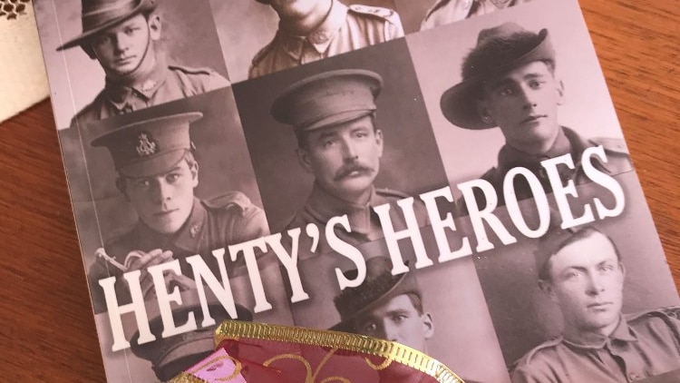 A book called Henty's Heroes lying on a table with a ribbon wrapped around it