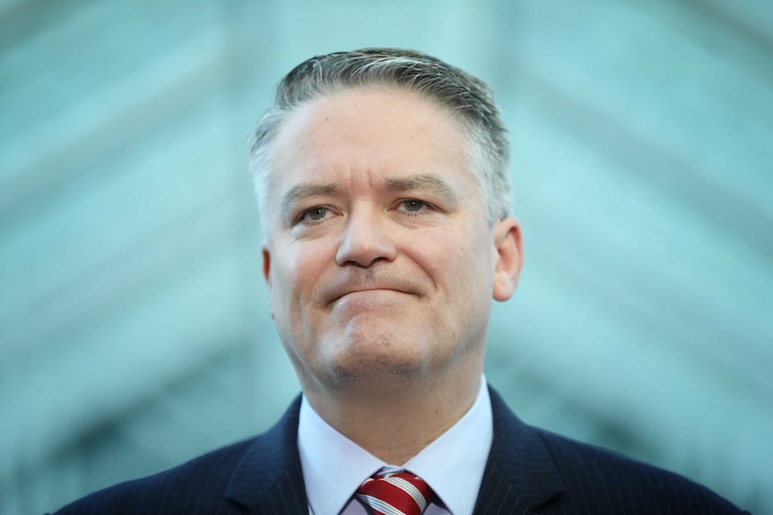 Tight shot of Cormann, lips held together, looking straight ahead.