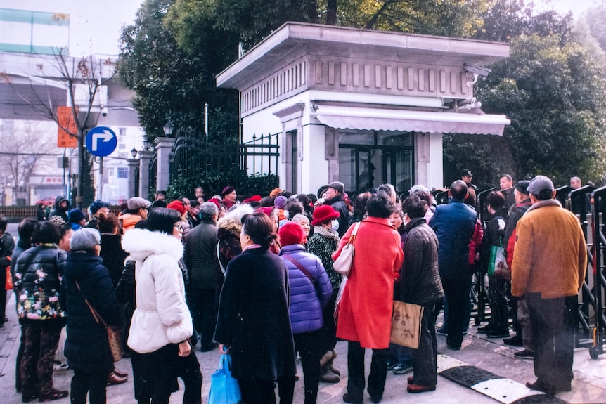 A crowd of people outside an official building.