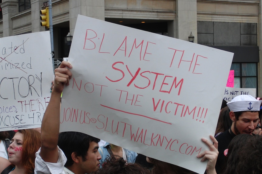 A protestor holds up a sign to oppose victim blaming as part of SlutWalk in New York City.