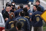Former Peruvian president Alberto Fujimori (far left) is surrounded by Chilean detectives before boarding a police helicopter.