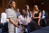 Four women standing side by side in court 