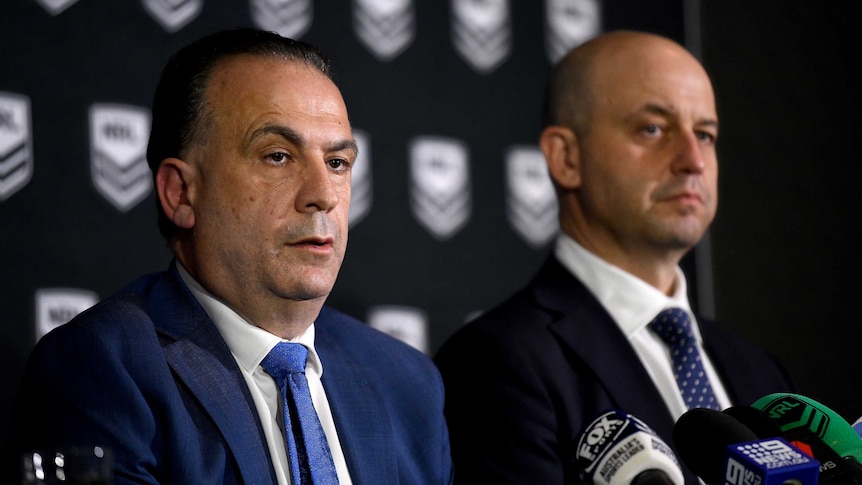 Two men sit at a table during an NRL press conference.