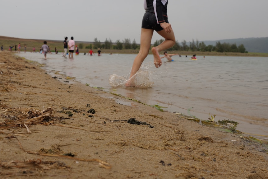 A child's feet splash through the water. 