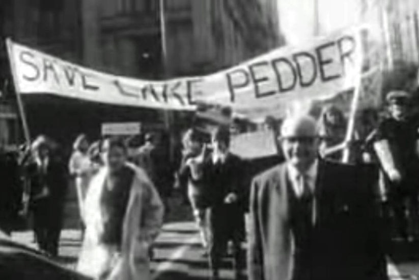 A black-and-white image of people in a Hobart street with signs campaigning against the flooding of Lake Pedder