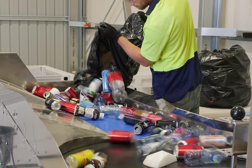 An image of a fast-spinning sorting machine processing an assortment of plastic bottles and aluminium cans
