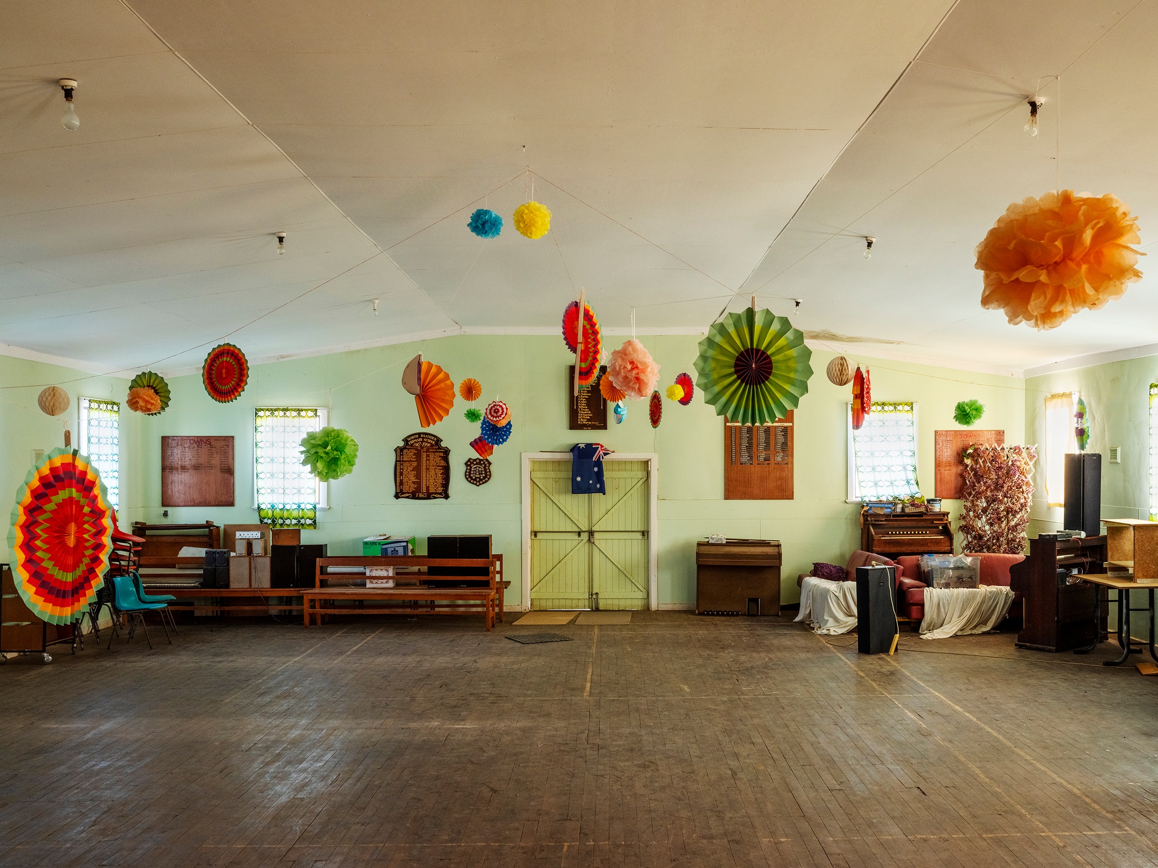 Empty country hall with bright paper decorations hanging from ceiling
