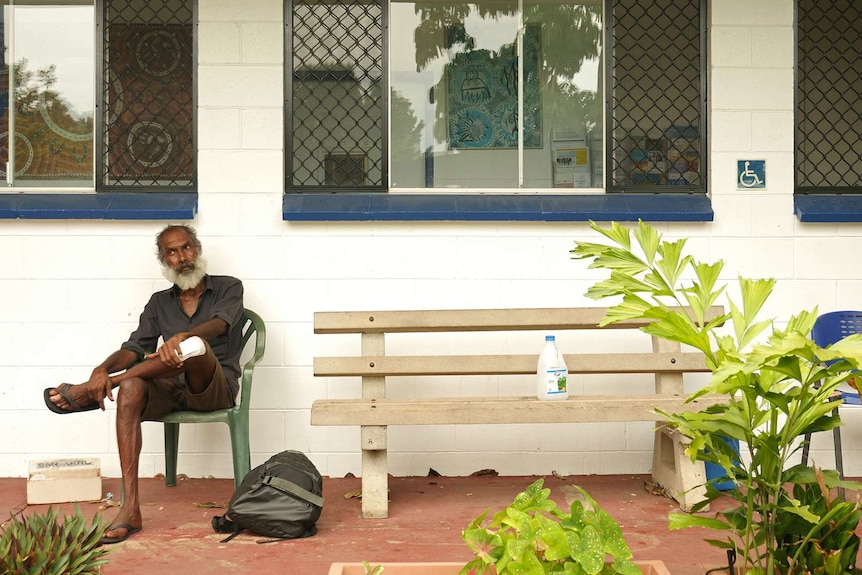 a photo of a long grasser sitting on a seat next to a bench.