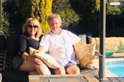 Maureen Carlisle and John Leedham sit by a pool
