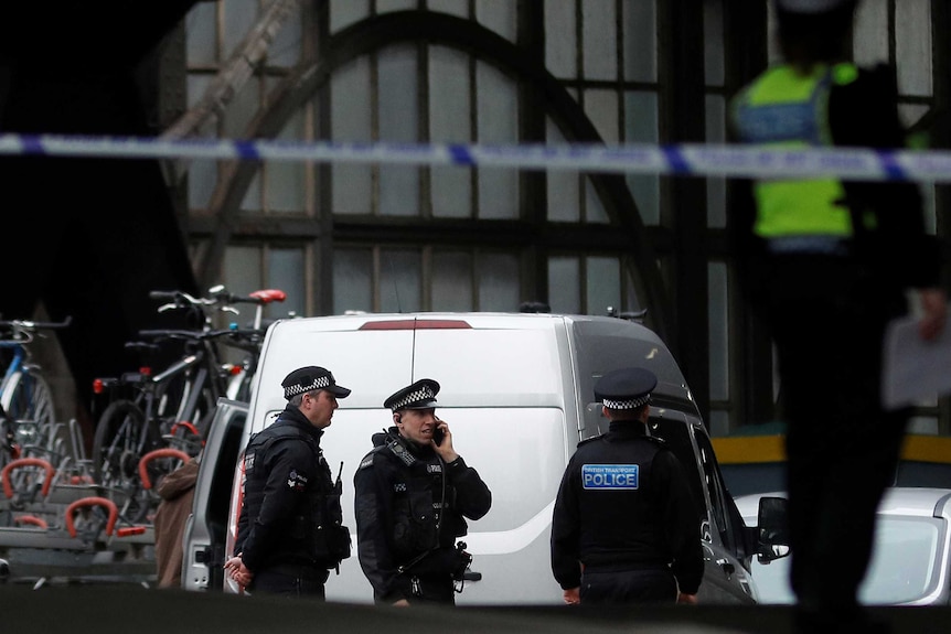 Police tape in foreground, police in background