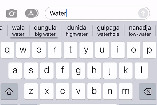 A phone keyboard showing English words with the Indigenous language translations below it.