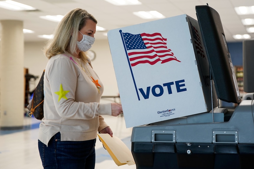 A voter casts their ballot as the governor's race in Virginia remains the most closely watched contest