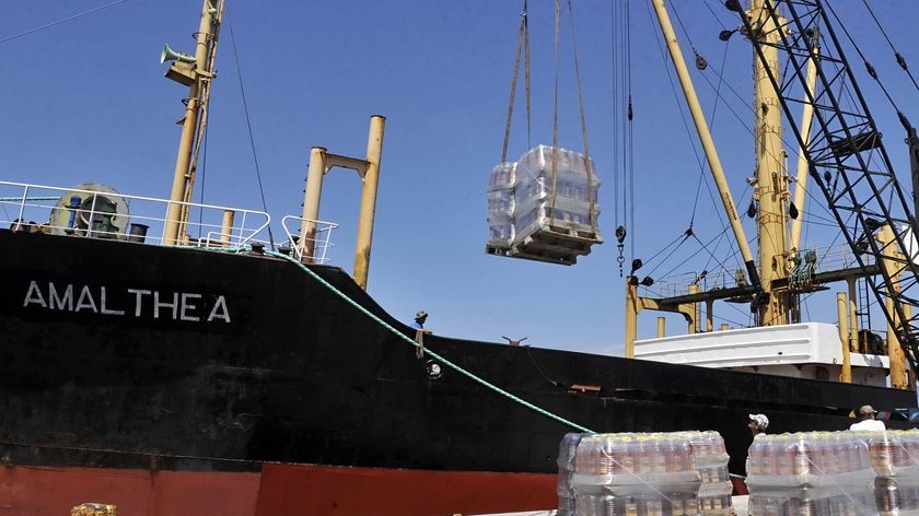 Crates of cooking oil are loaded on to the cargo ship 'Amalthea'