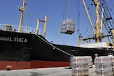 Crates of cooking oil are loaded on to the cargo ship 'Amalthea'