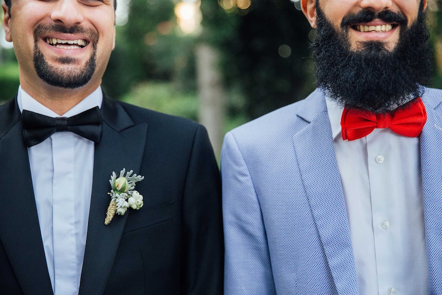 Two men with beards wear suits and bow ties to depict how to find the perfect suit.