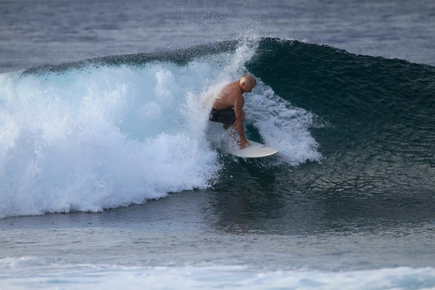 A man surfing inside a tube on a surfboard