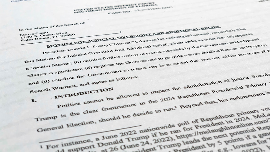 a close-up photograph of a court filing document citing 'president donald j trump' as the 'movant'