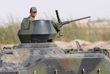 A Turkish soldier stands guard in an armoured personnel carrier