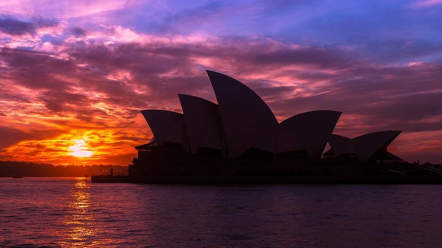 The sun sets behind the Sydney Opera house