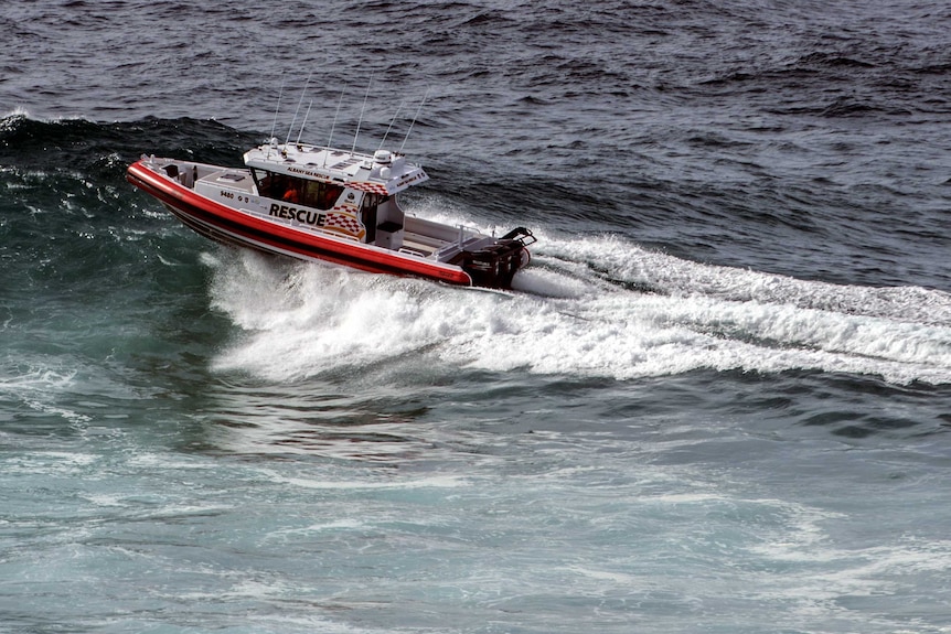 A sea rescue boat on a wave in the ocean.