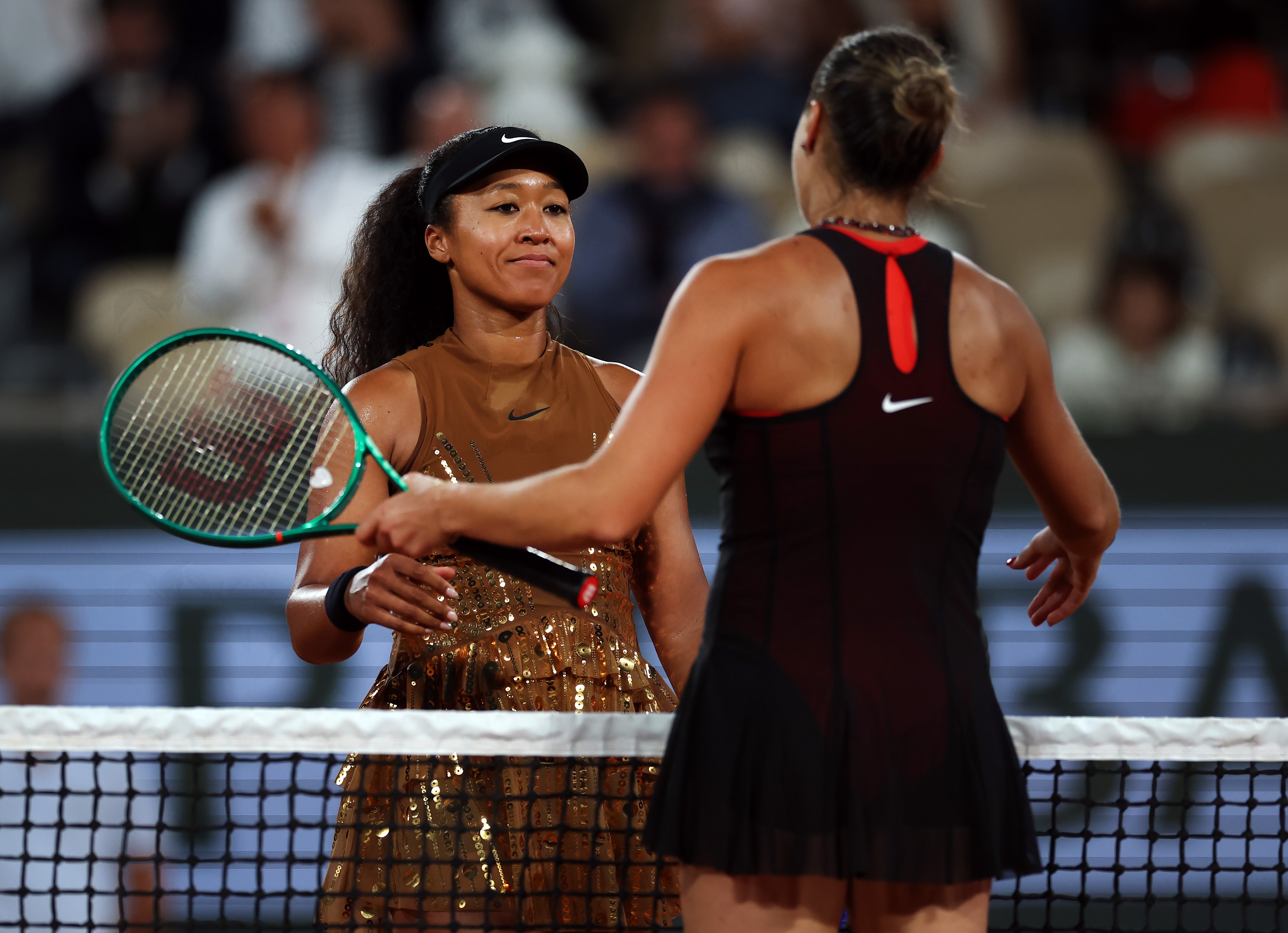 Naomi Osaka hugs Aryna Sabalenka at the net after their French Open match.
