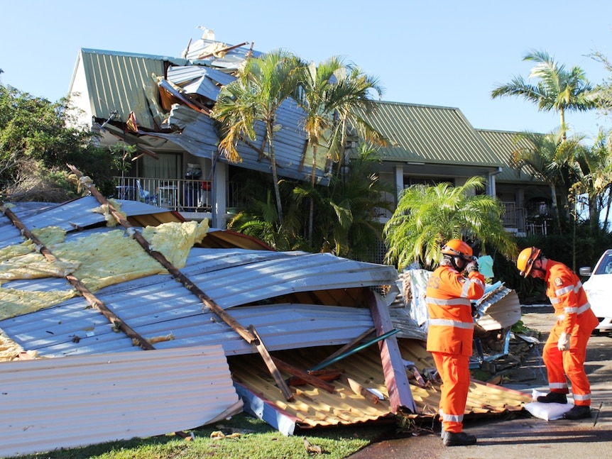 SES workers in front of destroyed unit blocks.