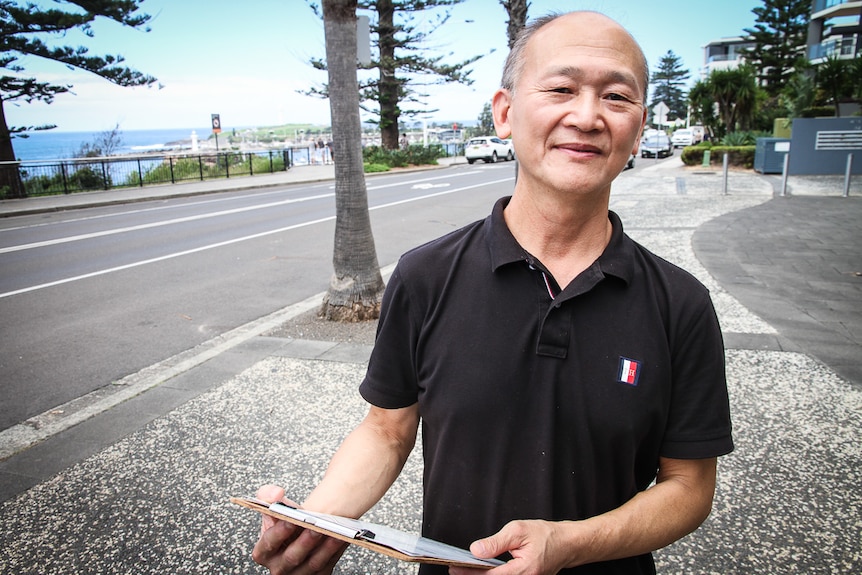 A Chinese man stands on Cliff Road in Wollongong