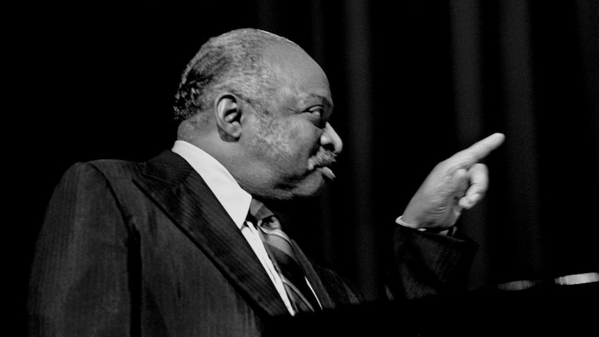 A monochrome shot of Count Basie at the piano