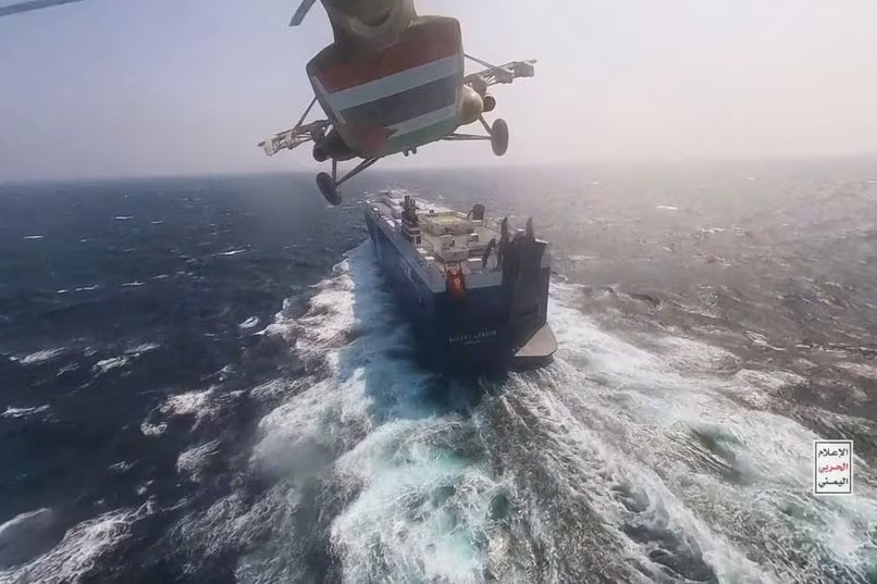 Вертолет летит над грузовым кораблем в океане