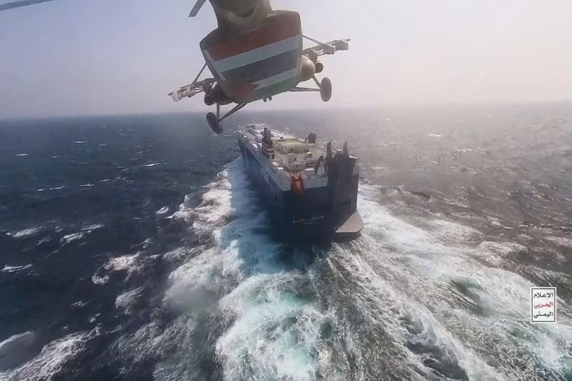 A helicopter flying above a cargo ship in the ocean