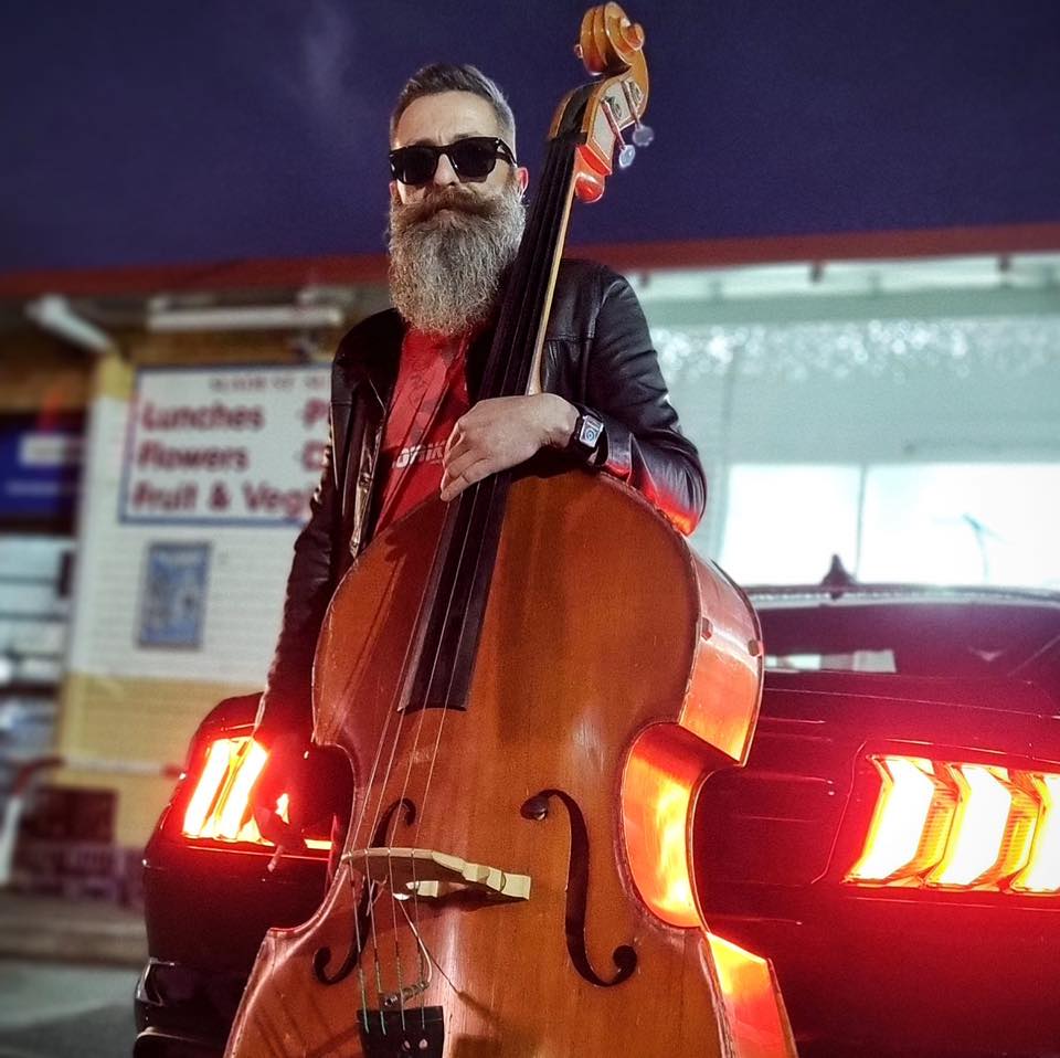 A man with a beard and a bass