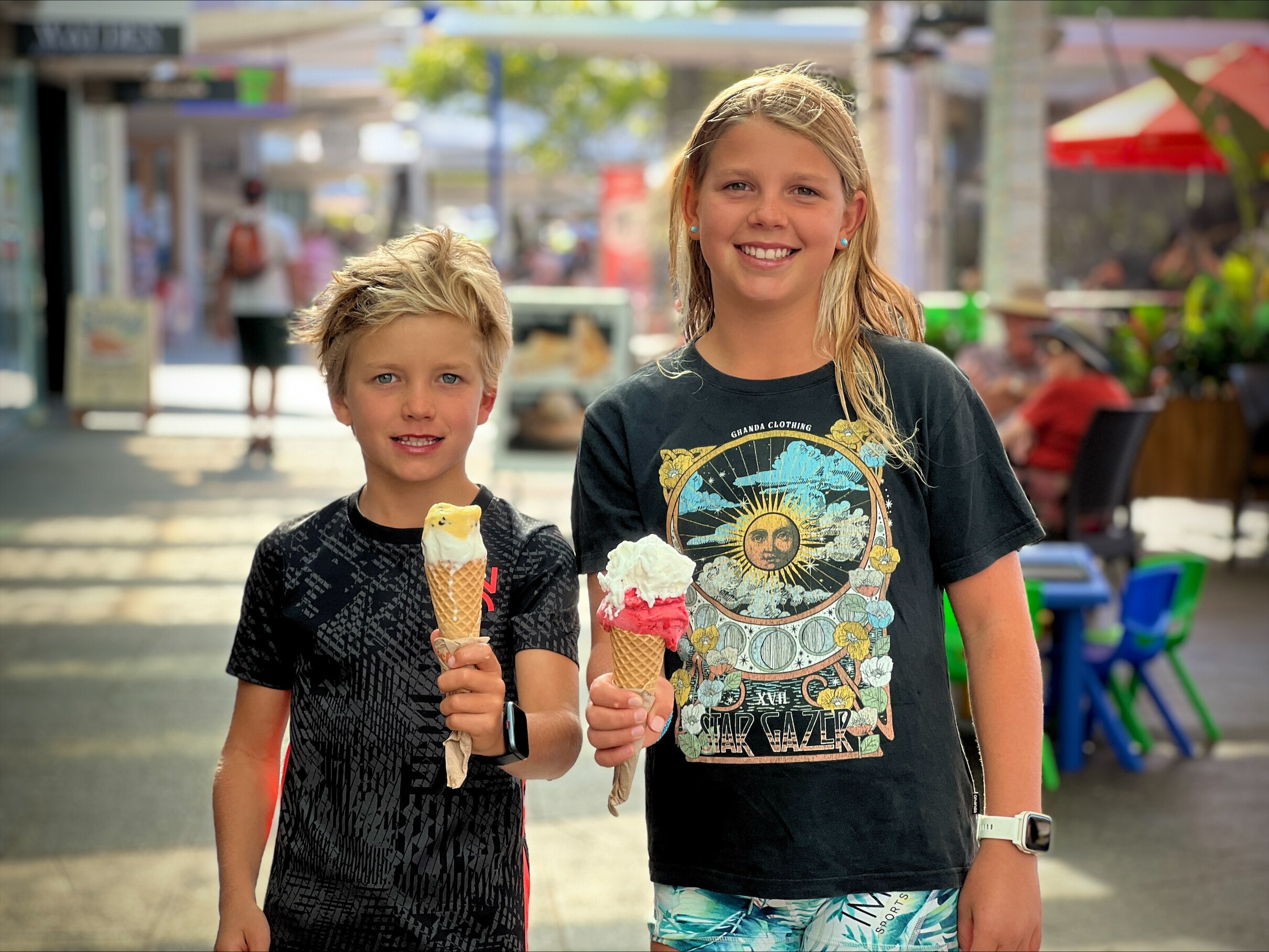 Two kids stand with ice creams