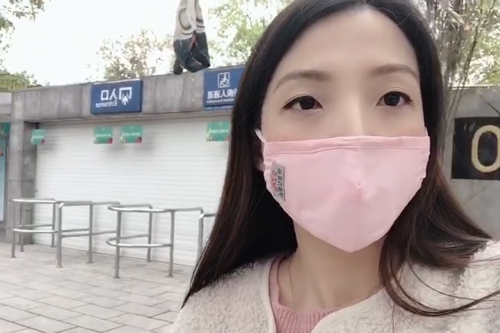 A young Chinese woman in a pink facemask