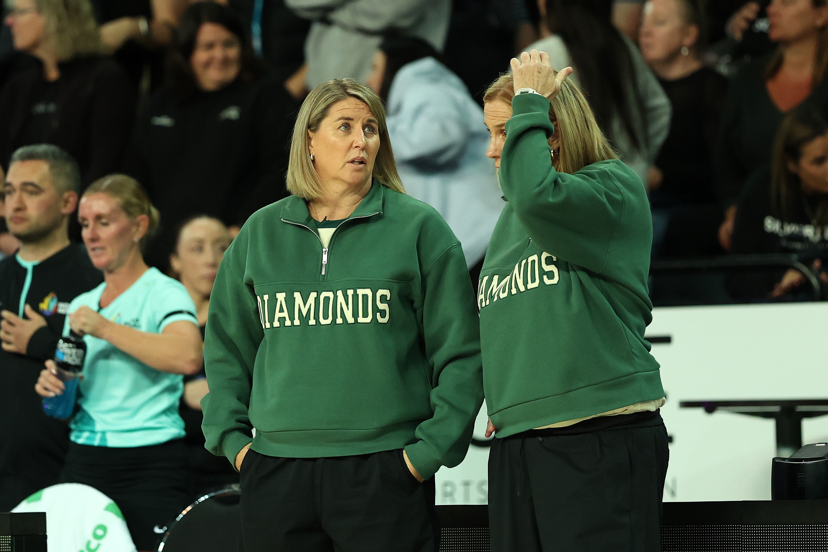 Two coaches look crestfallen and one scratches their head after a loss