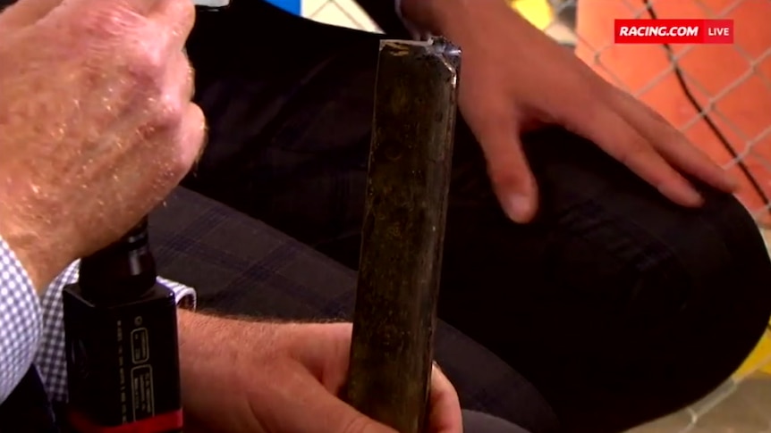 A man holds a metal stake, which was found on Kilmore race track during a meet.