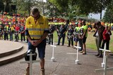 A worker lays a hard hat in memory of an Australian who died at work this year.