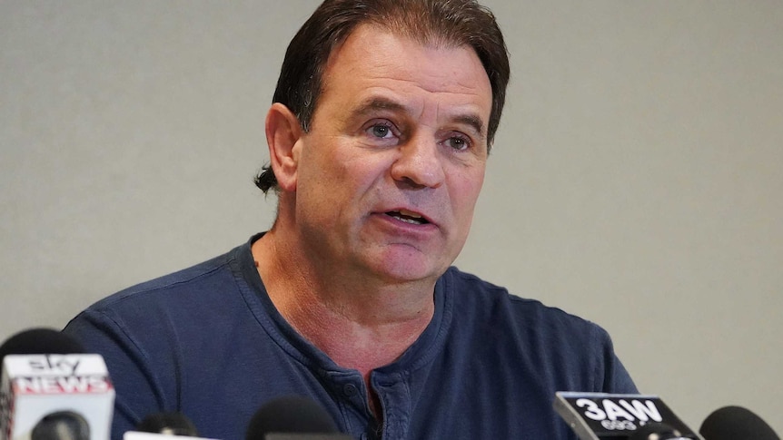 John Setka sitting behind a number of microphones at a Melbourne media conference.