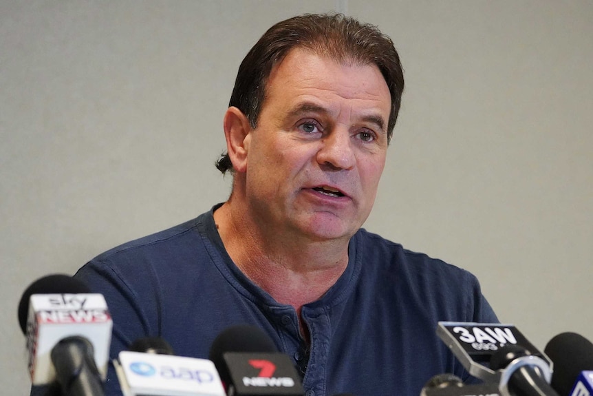 John Setka sitting behind a number of microphones at a Melbourne media conference.