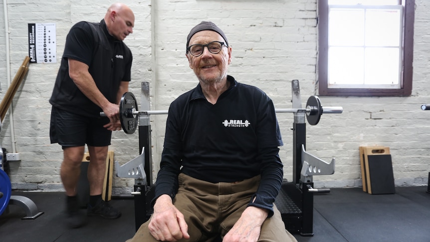 Former advertising consultant, Tony sitting on a gym bench smiling.