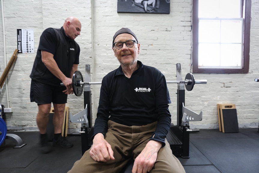 Former advertising consultant, Tony sitting on a gym bench smiling.