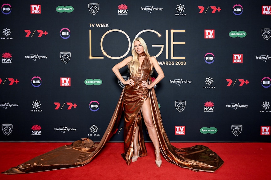 A woman wearing a long copper gown on the red carpet