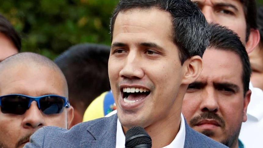 Venezuela's opposition leader Juan Guaido speaks into a microphone at a rally.