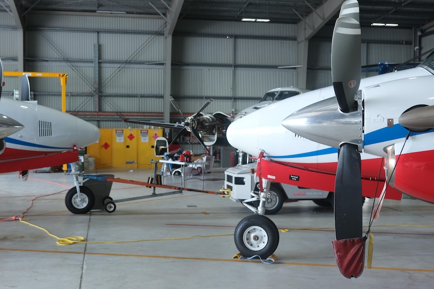 Small planes in a hangar.