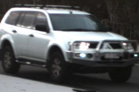 A grainy photo of a white four-wheel drive.