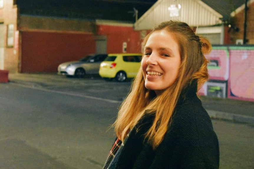 Eliza Katsourakis smiles at the camera on a street.
