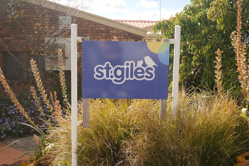 A sign reads 'St Giles' and is surrounded by tall flowers.