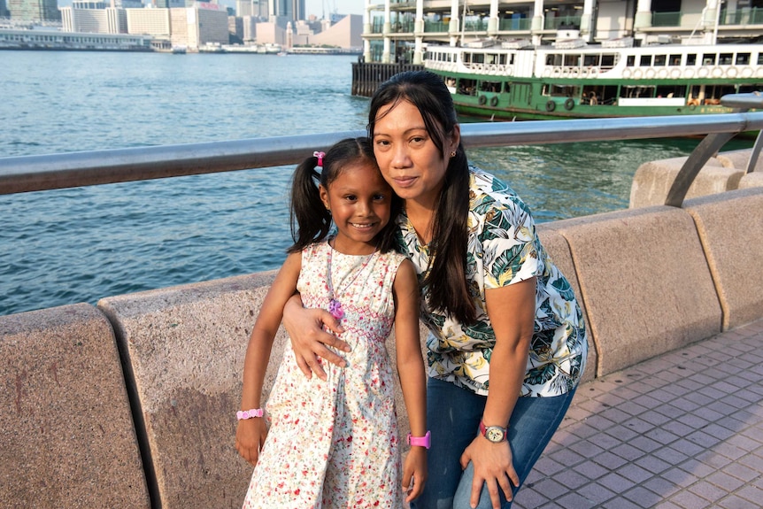 Vanessa Rodel and Keana pose in front of the water and a boat.