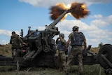 Servicemen fire a shell from a howitzer long range weapon launcher.